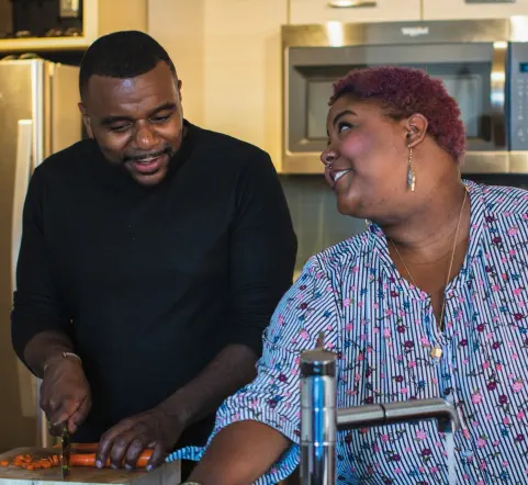 A man and woman are preparing a meal together in the kitchen